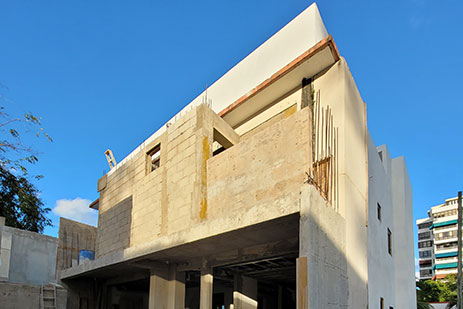 House exterior under construction with partially built concrete walls and exterior improvements in progress.